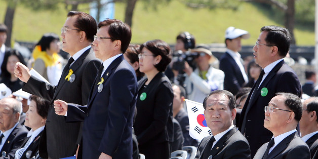 2014년 5월 18일, 국가보훈처가 5·18기념식에서 '님을 위한 행진곡' 제창을 거부해 유족과 5월 단체들이 기념식에 불참한 가운데 18일 오전 광주 북구 운정동 국립 5·18민주묘지에서 열린 5·18기념식에서 박준영 전남지사 등 일부 인사들이 일어서서 '님을 위한 행진곡'을 부르자 박승춘 보훈처장이 다른 곳을 보고 있다.