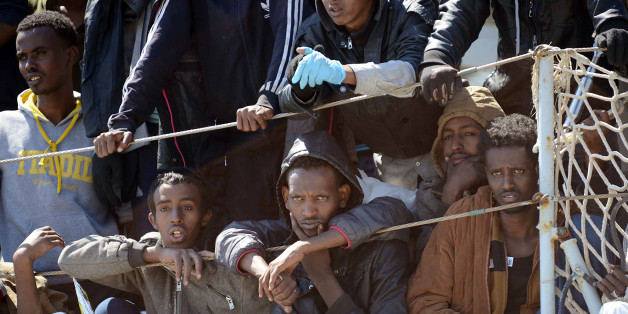 Migrants wait to disembark from the Italian Navy vessel 'Chimera' in the harbor of Salerno, Italy, Wednesday, April 22, 2015. Italy pressed the European Union on Wednesday to devise concrete, robust steps to stop the deadly tide of migrants on smugglers' boats in the Mediterranean, including setting up refugee camps in countries bordering Libya. Italian Defense Minister Roberta Pinotti also said human traffickers must be targeted with military intervention. (AP Photo/Francesco Pecoraro)