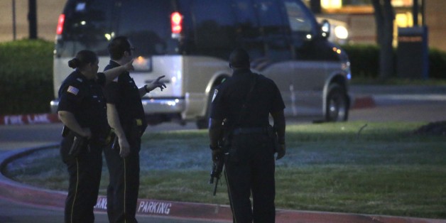Police officers stands guard at a parking lot near the Curtis Culwell Center where a provocative contest for cartoon depictions of the Prophet Muhammad was held Sunday, May 3, 2015, in Garland, Texas. The contest was put on lockdown Sunday night and attendees were being evacuated after authorities reported a shooting outside the building. (AP Photo/LM Otero)
