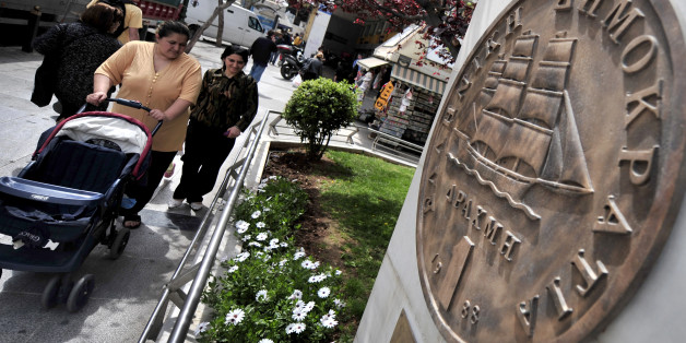 Pedestrians walk past a huge replica of the last edition of the old Greek drachma in central Athens on April 16, 2010. The euro extended recent losses against the dollar Friday on intensifying worries over Greece's debt problems as the set the stage for a request for emergency loans, analysts said. Greek Prime Minister George Papandreou on Friday signalled that Athens is preparing to request huge emergency loans from Europe and the IMF in what would be an unprecedented move by a euro nation. AFP PHOTO / Aris Messinis (Photo credit should read ARIS MESSINIS/AFP/Getty Images)