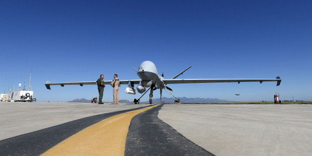 Lothar Eckardt, right, executive director of National Air Security Operations at U.S. Customs and Border Protection, speaks with a Customs and Border Patrol agent prior to a drone aircraft flight, Wednesday, Sept 24, 2014 at Ft. Huachuca in Sierra Vista, Ariz. The U.S. government now patrols nearly half the Mexican border by drones alone in a largely unheralded shift to control desolate stretches where there are no agents, camera towers, ground sensors or fences, and it plans to expand the strategy to the Canadian border. It represents a significant departure from a decades-old approach that emphasizes boots on the ground and fences. (AP Photo/Matt York)