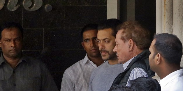 Bollywood actor Salman Khan, center, and his father Salim Khan, second right, come out of their residence to see off a guest in Mumbai, India, Thursday, May 7, 2015. One of India's biggest and most popular movie stars, Khan, was sentenced to five years in jail Wednesday on charges of driving a vehicle over five men sleeping on a sidewalk and killing one in a hit-and-run case that has dragged for more than 12 years. (AP Photo/Rajanish Kakade)