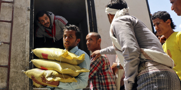 A Yemeni volunteer carries bags of rice to displaced people, who fled fighting in the southern city of Aden, during a food distribution effort by Yemeni volunteers, in Taiz, Yemen, Saturday, May 9, 2015. Humanitarian organizations say they face challenges delivering aid to citizens affected by the ongoing conflict, because of a severe fuel shortage and difficulty accessing warehouses. (AP Photo/Abdulnasser Alseddik)