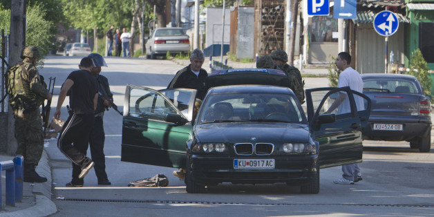 Macedonian special unit members search a vehicle as a fighting between police forces and members of an armed group resumes for a second day, in northern Macedonian town of Kumanovo, Sunday, May 10, 2015. (AP Photo/Visar Kryeziu)