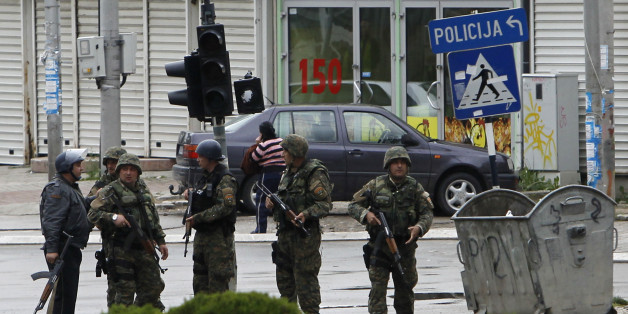 Police officers walk through a street near the scene of an altercation involving the police, in northern Macedonian town of Kumanovo, on Saturday, May 9, 2015. Authorities in Macedonia say police have clashed with an armed group in the northern town of Kumanovo, and parts of the town have been sealed off. (AP Photo/Boris Grdanoski)