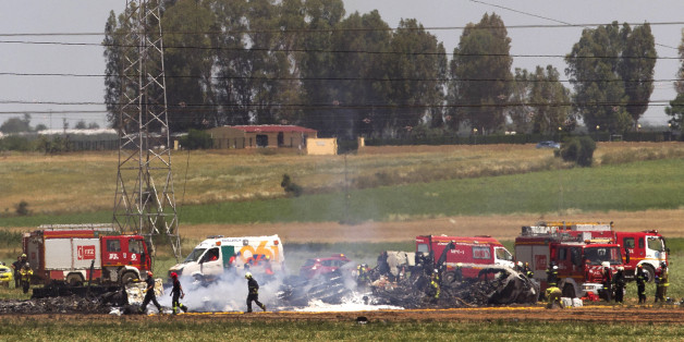 Emergency services personnel work at the scene after a plane crash near the Seville airport, in Spain, Saturday, May 9, 2015. A military transport plane crashed near southwestern Seville airport Saturday, killing its crew, Spain's prime minister said. It is unclear if any others were injured. Mariano Rajoy said up to 10 crew members were aboard the brand new Airbus A400M aircraft that was undergoing flight trials at the airport. (AP Photo/Miguel Angel Morenatti)