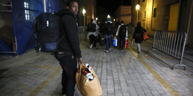 In this Wednesday, April 22, 2015 photo, migrants make their way to accommodate themselves after being processed by the Greek Coast Guard at the southeastern island of Rhodes. Arrivals in Greece have more than doubled this year to exceed 10,000 _ including more than 1,000 in the past week alone _ as scores of people arrive daily on islands close to the Turkish coast. From there, they register with Greek authorities and then make their way by ferry to Athens, hoping to continue their clandestine