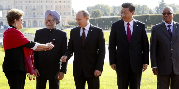 FILE - In this Sept. 5, 2013 file photo, from left, Brazil's President Dilma Rousseff gestures to then Indian Prime Minister Manmohan Singh, Russia's President Vladimir Putin, China's President Xi Jinping and South African President Jacob Zuma, as they gather for a group photo after a BRICS leaders' meeting at the G-20 Summit in St. Petersburg, Russia. In another sign of the shifting balance of power in the world economy, emerging market powers Brazil, Russia, India, China and South Africa are launching a $100 billion development bank to challenge the U.S.-dominated World Bank and help finance $4.5 trillion worth of infrastructure projects. (AP Photo/Sergei Karpukhin, Pool, File)