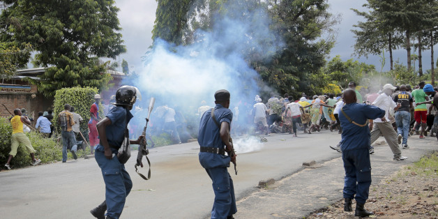 Demonstrators trying to march to the town center flee as police disperse them with tear gas, in the Ngagara district of Bujumbura, Burundi Wednesday, May 13, 2015. A police officer opened fire at protesters in Burundi's capital Wednesday as demonstrations against the president's bid for a third term heated up, with troops surrounding the national radio station. (AP Photo/Gildas Ngingo)