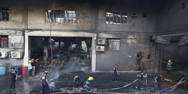 Firemen work to put the fire under control at a still-smoldering Kentex rubber slipper factory in Valenzuela city, a northern suburb of Manila, Philippines, Wednesday, May 13, 2015. A fire gutted the factory, possibly killing dozens of workers who ran to the second floor in hopes of escaping only to become trapped by inferno, officials said. Fire officials said there were no survivors found after the fire was put under control, said Mayor Rex Gatchalian of Valenzuela. (AP Photo/Bullit Marquez)