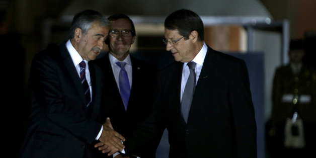 Cyprus' president Nicos Anastasiades, right, shakes hands with Turkish Cypriot leader Mustafa Akinci as the United Nations envoy Espen Barth Eide, center, looks on before a dinner at the Ledra Palace Hotel inside the UN controlled buffer zone that divides the Cypriot capital Nicosia, on Monday, May 11, 2015. The dinner is the first meeting between Anastasiades and Akinci since the Turkish Cypriot politician _ a left-wing moderate _ soundly defeated the hard-line incumbent in an election last month. Cyprus was split in 1974 when Turkey invaded after a coup by supporters of union with Greece. (AP Photo/Petros Karadjias)