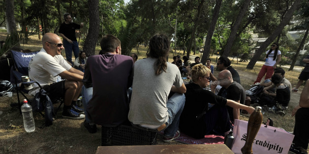 TO GO WITH AFP STORY by Roland Lloyd Parry: Patricipants of a time-exchange network stage a pic-nic for new members at an Athens park on May 27, 2012 to indroduce an online exchange where members swap services, counting the cost not in euros, but in hours. More than 1,000 people are registered on the Athens time bank, of which around 200 active members regularly use it to give and receive services. Time-banking and other forms of bartering are on the rise in Greece and other crisis-hit countries such as Spain, as people come to grips with lower salaries, pensions and job prospects. AFP PHOTO/ LOUISA GOULIAMAKI (Photo credit should read LOUISA GOULIAMAKI/AFP/GettyImages)
