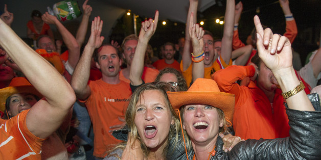 People celebrate as they watch the Dutch team win after penalties in the World Cup quarter finals soccer match between the Netherlands and Costa Rica at Strandzuid in Amsterdam, Saturday, July 5, 2014. (AP Photo/Patrick Post)