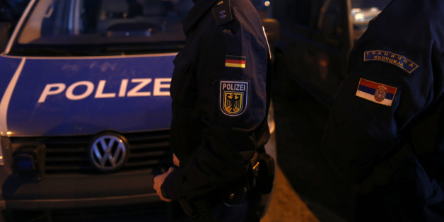 A member of the German border police, center, passes by his vehicle while monitoring a stretch of the Serbian border with Hungary in the village of Hajdukovo, some 180 kilometers north of Belgrade, Serbia, Friday, Feb. 13, 2015. Some 20 German police officers, equipped with vehicles with thermal vision cameras, joined Serbian security forces on Serbia's border with Hungary on Friday to try to halt a torrent of migrants that has alarmed many European Union countries. (AP Photo/Darko Vojinovic)
