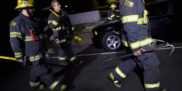 PHILADELPHIA, PA - MAY 13: Fire fighters carry tools back to their truck in the early hours after working at the wreckage of an Amtrak passenger train that derailed carrying more than 200 passengers from Washington, DC to New York on May 13, 2015 in north Philadelphia, Pennsylvania. At least five people were killed and more than 50 others were injured in the crash. (Photo by Mark Makela/Getty Images)