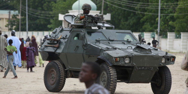 FILE - In this Thursday, Aug. 8, 2013 file photo, Nigerian soldiers ride on an armored personnel carrier during Eid al-Fitr celebrations in Maiduguri, Nigeria. Hundreds of Boko Haram extremists tried to attack the biggest army base in northeast Nigeria overnight but met fierce resistance from soldiers who fired artillery throughout the night. Booming cannon and whooshing rockets woke people living around Giwa Barracks in Maiduguri, the northeast's biggest city. Hundreds fled though some were returning home Thursday, May 14, 2015. Many villagers were killed by shells that hit the outlying village of Kayamla, where the soldiers engaged hundreds of militants, according to Muhammad Gava, a hunter who is secretary of the self-defense Vigilante Group of Nigeria. (AP Photo/Sunday Alamba, File)