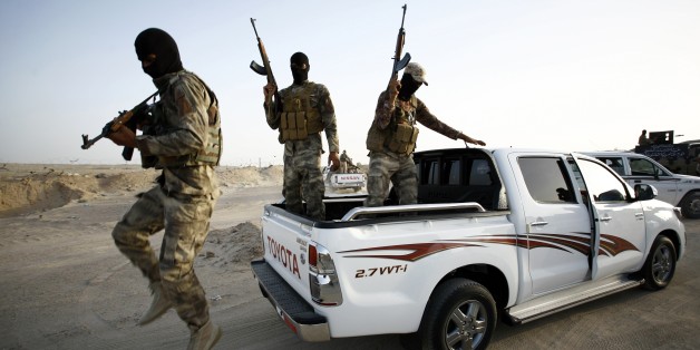 Iraqi Sunni men presented as former jihadists fighting alongside the Islamic State (IS) group who defected to join Iraq government forces take position in Amriyat al-Fallujah, in Iraq's Anbar province, on May 26, 2015. Iraqi forces took up positions on the southern outskirts of Ramadi, officials said, taking two neighbourhoods and moving into Anbar university. Army and police forces as well as allied paramilitaries clashed with IS fighters to take full control of Taesh and Humeyrah, an army colo