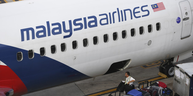 A Malaysia Airlines ground staff member unloads luggage from a plane at Kuala Lumpur International Airport in Sepang, Malaysia Monday, June 1, 2015. The new CEO of Malaysia Airlines said the ailing carrier could break even by 2018 after cutting staff, selling surplus aircraft and refurbishing its international fleet. (AP Photo/Vincent Thian)
