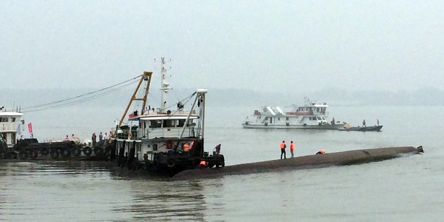 Chinese rescue boats are seen alongside a capsized passenger ship carrying more than 450 people which sunk in the Yangtze river, triggering a rescue effort hampered by strong winds and heavy rain off Jianli in China's Hubei province on June 2, 2015. The ship named Dongfangzhixing, or 'Eastern Star', was headed from the eastern city of Nanjing to the southwestern city of Chongqing when it sank in the Jianli section of the river. CHINA OUT AFP PHOTO (Photo credit should read