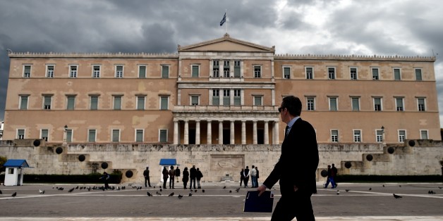 A woman walks in front of the Greek Parliament in Athens on April 7, 2015. Greek lawmakers voted on April 7 to set up a committee to examine the circumstances under which Greece agreed to bailouts totaling 240 billion euros (USD 260 billion) with the European Union and International Monetary Fund. AFP PHOTO / ARIS MESSINIS (Photo credit should read ARIS MESSINIS/AFP/Getty Images)