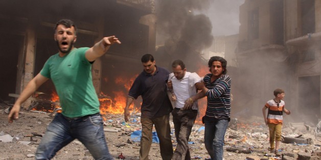 Syrian men react and help the inured following a reported barrel bomb attack by Syrian government forces that hit an open market in the northern city of Aleppo, on June 3, 2015, killing and injuring people. Regime barrel bombs -- crude weapons made of containers packed with explosives -- have often struck schools, hospitals, and markets in Syria. AFP PHOTO / KARAM AL-MASRI (Photo credit should read KARAM AL-MASRI/AFP/Getty Images)