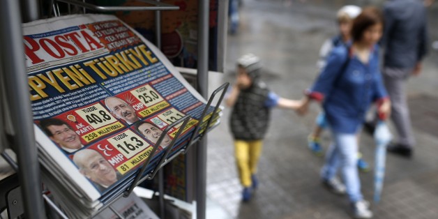 People walk past a kiosk with newspapers featuring front-page coverage of Sunday's elections, in Istanbul, Turkey, Monday, June 8, 2015. Turkeyâs long-ruling party has suffered surprisingly strong losses in parliament that will force it to seek a coalition partner for the next government, but other parties vowed to resist any pact as election results flowed in Monday. President Recep Tayyip Erdogan's Justice and Development Party, known as the AKP, won less than 41 percent of votes in Sunday's election for Turkeyâs 550-seat parliament. It was projected to take 258 seats, still top of the political heap but 18 below the minimum required to rule alone. (AP Photo/Emrah Gurel)