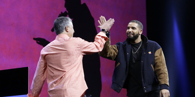 Musician Drake, right, high fives Eddy Cue, Apple senior vice president of Internet Software and Services, during the Apple Worldwide Developers Conference in San Francisco, Monday, June 8, 2015. The maker of iPods and iPhones announced Apple Music, an app that combines Beats 1, a 24-hour, seven-day live radio station, with an on-demand music streaming service. (AP Photo/Jeff Chiu)