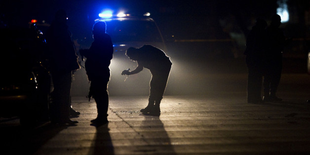 Investigators work at the scene where two men were murder in Tijuana, Mexico, late Friday, March 4, 2011. According to police, two men died and other was injured after being shot by unknown gunmen. (AP Photo/Guillermo Arias)