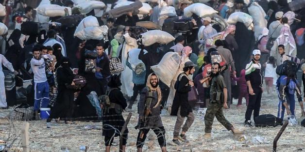 Des membres du groupe EI demandent aux habitants de retourner dans leur ville en Syrie, à la frontière avec la Turquie, le 13 juin 2015