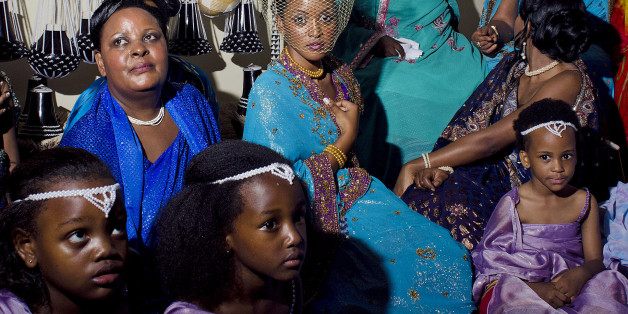 Princess Ruth Komuntale (C) of the Ugandan Toro kingdom poses with children before an introduction ceremony, at the Gweri village, eight kilometers from Fort Portal, on November 15, 2012. Komuntale will marry Christopher Thomas a young Missourian accountant working for the Discovery Channel in the U.S.. As part of the ceremony Thomas must be formally introduced and accepted by Toro's royal family. The couple are due to marry on November 17, 2012. AFP PHOTO / MIchele Sibiloni (Photo credit should read MICHELE SIBILONI/AFP/Getty Images)