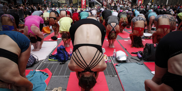 NEW YORK, NY - JUNE 21: People do yoga in Times Square as part of the International Day of Yoga celebration on the Summer Solstice June 21, 2015 in New York City. 192 countries joined in for a mass yoga session to mark the United Nations declared, International Yoga Day. (Photo by Kena Betancur/Getty Images)