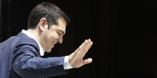 Greece's Prime Minister Alexis Tsipras waves to the media persons as he arrives at Maximos Mansion in Athens on Tuesday, June 23, 2015. The country this week offered a series of measures, including multiple tax increases, to persuade its creditors to release bailout funds and keep the country from defaulting on its debts as soon as next week. (AP Photo/Thanassis Stavrakis)