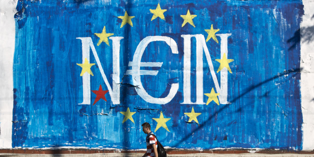 A man walks past a graffiti made by street artist N_Grams that read ''NO'' in German but also ''YES, IN'' in Greek language in Athens, on Sunday, June 28, 2015. Greece's parliament voted early Sunday in favor of Prime Minister Alexis Tsipras' motion to hold a July 5 referendum on creditor proposals for reforms in exchange for loans. (AP Photo/Petros Giannakouris)