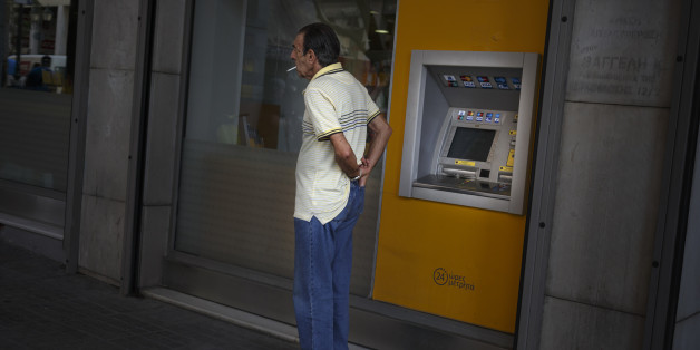 A man puts his wallet in his pocket after withdrawing euro notes from a bank machine in Athens, Thursday, June 25, 2015. The ECB approved a request from Athens to increase the amount of emergency liquidity Greek lenders can tap from the country's central bank. Worried Greeks have been withdrawing their money from their country's banks, fearing the imposition of restrictions on banking transactions. An estimated more than 4 billion euros ($4.5 billion) left Greek banks last week. (AP Photo/Daniel Ochoa de Olza)
