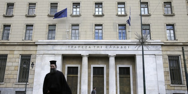 A Greek Orthodox priest crosses the street outside of Bank of Greece headquarters in Athens, Friday, June 19, 2015. Several European countries said openly they are getting ready for the possibility of Greece leaving the euro. And though there was no sign of panic in the streets of Greece over that prospect, officials say Greeks are taking money out of banks in growing amounts. (AP Photo/Thanassis Stavrakis)