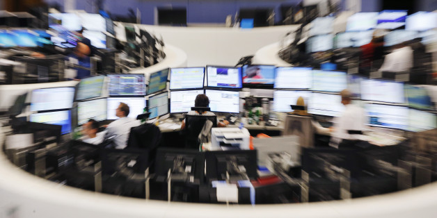 Traders sit in front of their screens at the stock market in Frankfurt, Germany, Monday, June 29, 2015. The German stock index DAX lost around 500 point right after the opening of the stock market. (AP Photo/Michael Probst)