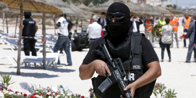 A hooded Tunisian police officer stands guard ahead of the visit of top security officials of Britain, France, Germany and Belgium at the scene of Friday's shooting attack in front of the Imperial Marhaba hotel in the Mediterranean resort of Sousse, Tunisa, Monday, June 29, 2015. The top security officials of Britain, France, Germany and Belgium are paying homage to the people killed in the terrorist attack on Friday. (AP Photo/Abdeljalil Bounhar)