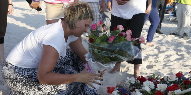 An unidentified tourist places flowers at the scene of Friday's shooting attack in the coastal town of Sousse, Tunisia, Sunday, June 28, 2015. The Friday attack on tourists at a beach is expected to be a huge blow to Tunisia's tourism sector, which made up nearly 15 percent of the country's gross domestic product in 2014. (AP Photo/Abdeljalil Bounhar)