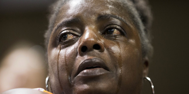 Barbara Lloyd, of Charleston, S.C., cries during the singing of "We Shall Overcome" at a memorial service for the victims of the shooting at Emanuel AME Church, Friday, June 19, 2015, in Charleston, S.C. (AP Photo/David Goldman)