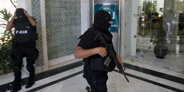 Tunisian police officers guard the Imperial Marhaba hotel during visit of top security officials of Britain, France, Germany and Belgium in Sousse, Tunisia, Monday, June 29, 2015. British Home Secretary Theresa May, French Interior Minister Bernard Cazeneuve, German Interior Minister Thomas de Maiziere and Belgian Interior Minister Jan Jambon joined their Tunisian counterpart on the beach in front of the Imperial Marhaba hotel in the Mediterranean resort of Sousse for a tribute to the dead and wounded on Monday. (AP Photo/Darko Vojinovic)