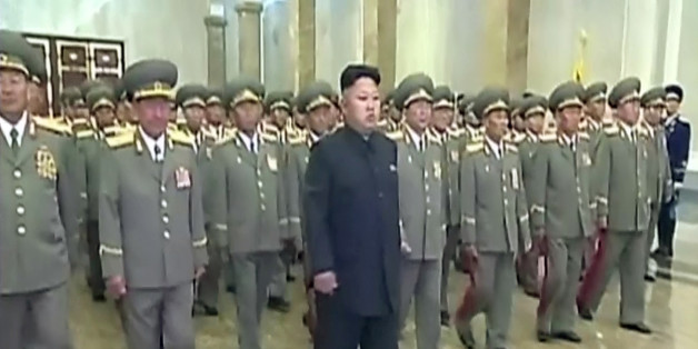 In this Tuesday, July 8, 2014 image made from video, North Korean leader Kim Jong Un, center, visits Kumsusan Palace of the Sun to mark the 20th anniversary of the death of its first leader, Kim Il Sung, in Pyongyang, North Korea. Kim seemed to have somehow hurt his leg enough to require a slight, but visible, limp as he marched across the stage Tuesday to assume his position of honor. He limped again as he left the room when the event was over. (AP Photo/KRT via AP Video) TV OUT, NORTH KOREA OU