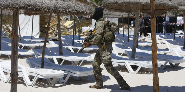 A hooded Tunisian police officer patrols ahead of the visit of top security officials of Britain, France, Germany and Belgium at the scene of Friday's shooting attack in front of the Imperial Marhaba hotel in the Mediterranean resort of Sousse, Tunisa, Monday, June 29, 2015. The top security officials of Britain, France, Germany and Belgium are paying homage to the people killed in the terrorist attack on Friday. (AP Photo/Abdeljalil Bounhar)
