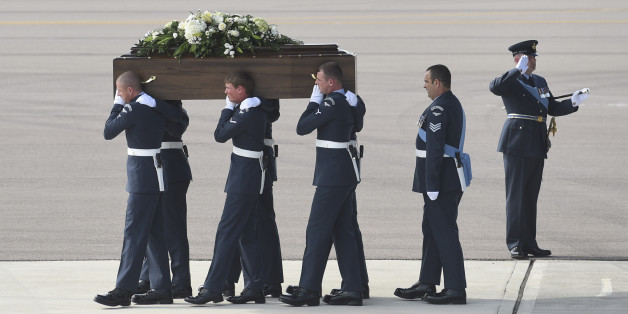 Pallbearers carry a coffin from a British RAF C-17 plane, confirmed as carrying the body of Adrian Evans, as the bodies of eight British nationals killed Friday in the Tunisia beach terror attack at RAF Brize Norton, England, Wednesday July 1, 2015. At least 27 Britons are confirmed among the 38 people shot dead when a Tunisian student opened fire on a beach in the North African nation's central resort of Sousse. (Joe Giddens / Pool photo via AP)