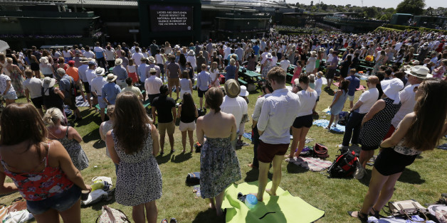 People observe the minute silence for the victims of the shooting in Tunisia last week, at the All England Lawn Tennis Championships in Wimbledon, London, Friday July 3, 2015. Fans and staff at Wimbledon observed a minuteâs silence for the victims of last Fridayâs attack in Tunisia, in which 30 Britons were killed in a shooting rampage at a beach resort in Sousse. Â The start of play at Wimbledon was delayed so the tournament could join in the national minuteâs silence. (AP Photo/Tim Ireland)