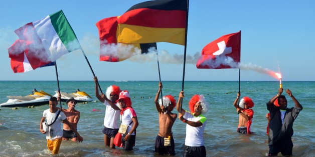 Tourists take part in a gathering in solidarity with Tunisia's tourism industry, on June 29, 2015 on the island of Djerba, following a deadly gun attack at a holiday resort near Sousse. Tunisia said it had made its first arrests after a beach massacre on June 26 that killed 38 people, as European officials paid tribute to victims of the country's worst jihadist attack. AFP PHOTO / FETHI NASRI (Photo credit should read FETHI NASRI/AFP/Getty Images)