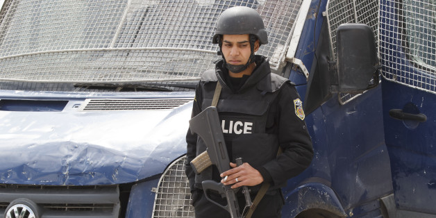An armed Tunisian police officer, stands guard at the morgue of the Charles Nicolle hospital in Tunis, Tunisia, Friday, March 20, 2015. The two extremist gunmen who killed 21 people at a museum in Tunis trained in neighboring Libya before caring out the deadly attack, a top Tunisian security official said. (AP Photo/Michel Euler)
