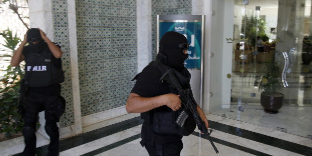 Tunisian police officers guard the Imperial Marhaba hotel during visit of top security officials of Britain, France, Germany and Belgium in Sousse, Tunisia, Monday, June 29, 2015. British Home Secretary Theresa May, French Interior Minister Bernard Cazeneuve, German Interior Minister Thomas de Maiziere and Belgian Interior Minister Jan Jambon joined their Tunisian counterpart on the beach in front of the Imperial Marhaba hotel in the Mediterranean resort of Sousse for a tribute to the dead and wounded on Monday. (AP Photo/Darko Vojinovic)