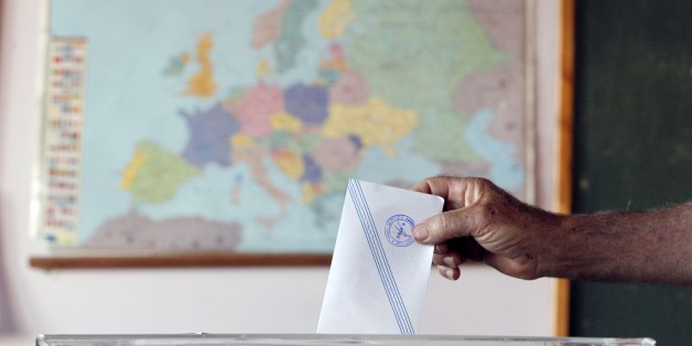 A man casts his vote as the map of Europe is seen in the background at a polling station in Athens, Sunday, July 5, 2015. Greeks began voting early Sunday in a closely-watched, closely-contested referendum, which the government pits as a choice over whether to defy the country's creditors and push for better repayment terms or essentially accept their terms, but which the opposition and many of the creditors paint as a choice between staying in the euro or leaving it. (AP Photo/Thanassis Stavrak