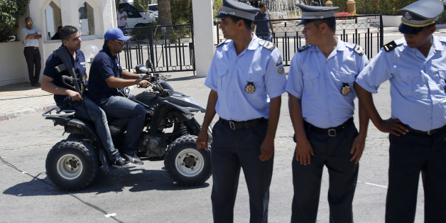 Tunisian police officers guard the Imperial Marhaba hotel during visit of top security officials of Britain, France, Germany and Belgium in Sousse, Tunisia, Monday, June 29, 2015. British Home Secretary Theresa May, French Interior Minister Bernard Cazeneuve, German Interior Minister Thomas de Maiziere and Belgian Interior Minister Jan Jambon joined their Tunisian counterpart on the beach in front of the Imperial Marhaba hotel in the Mediterranean resort of Sousse for the tribute Monday. (AP Pho