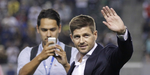 Newly acquired Los Angeles Galaxy midfielder Steven Gerrard, right, waves to the fans as he is introduced during halftime ceremonies of the team's MLS soccer match against Toronto FC in Carson, Calif., Saturday, July 4, 2015. Gerrard is scheduled to play for the Galaxy on July 17 against the San Jose Earthquakes in Carson. (AP Photo/Alex Gallardo)